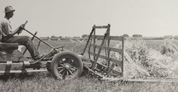 A homemade auto buck rake gathering up the shocks of bundled grain before 1940
