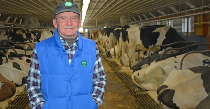 Jim Davenport standing in dairy barn with cattle