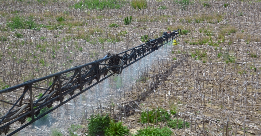 sprayer applying herbicide treatment to soybean field