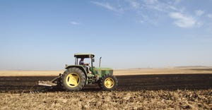 Tractor on barren wheat field