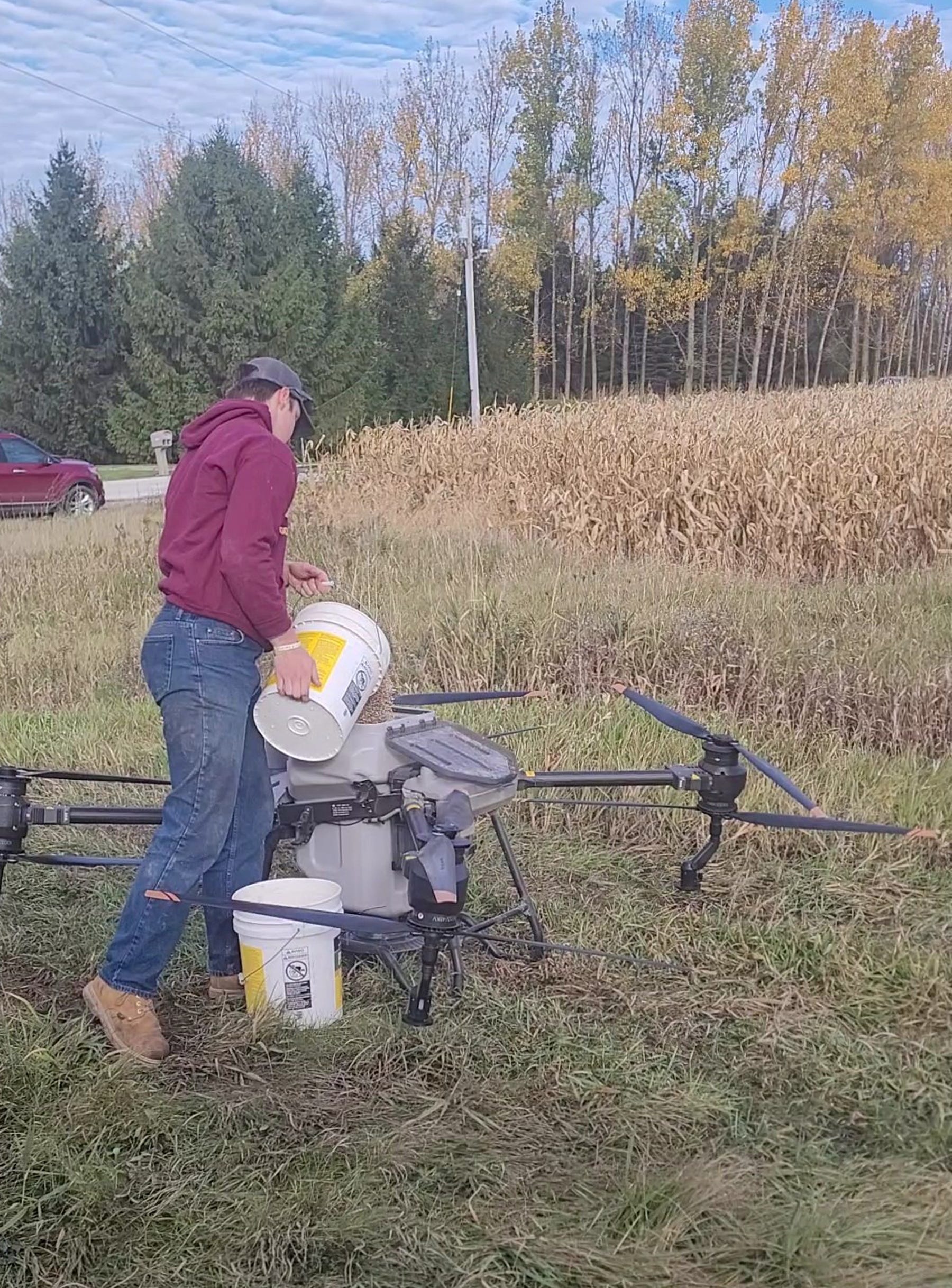 Cade Christensen from CAL Drone Applications LLC, fills a drone with cover crop seed. 
