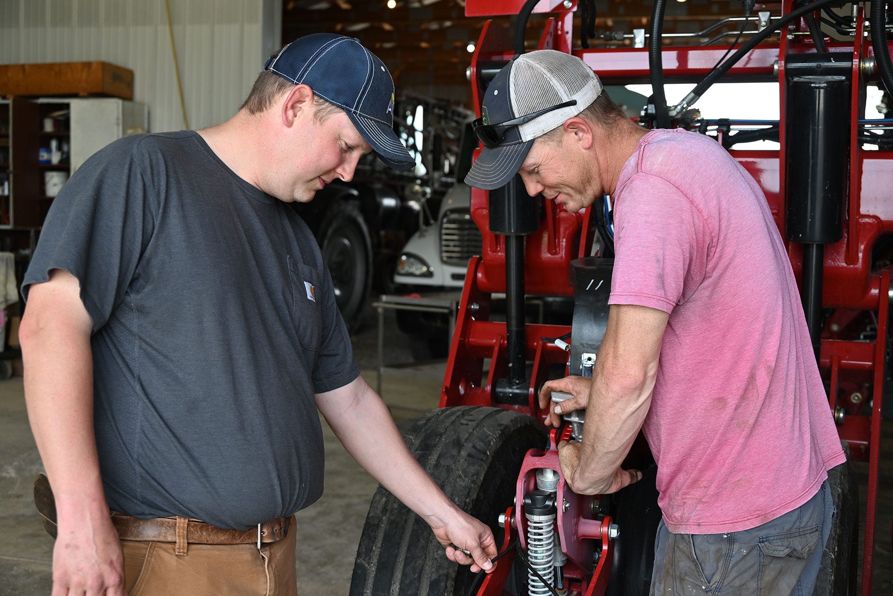 Brothers Carter and Brent Morgan work on farm machinery
