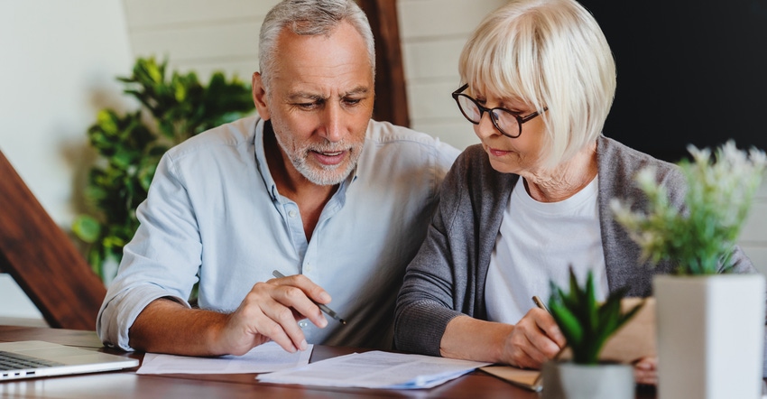 Mature couple with financial documents in home interior Mature couple with financial documents in home interior