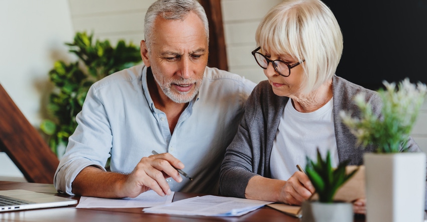 Mature couple with financial documents in home interior