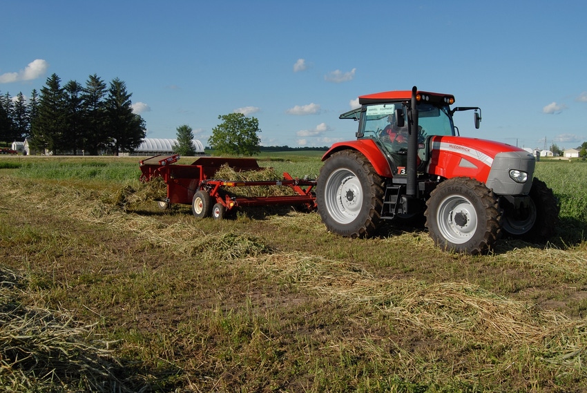 Hay equipment operating in alfalfa field Hay equipment operating in alfalfa field