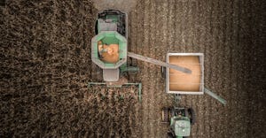  Looking down on the combine and tractor moving through the corn field using the drone to look down.