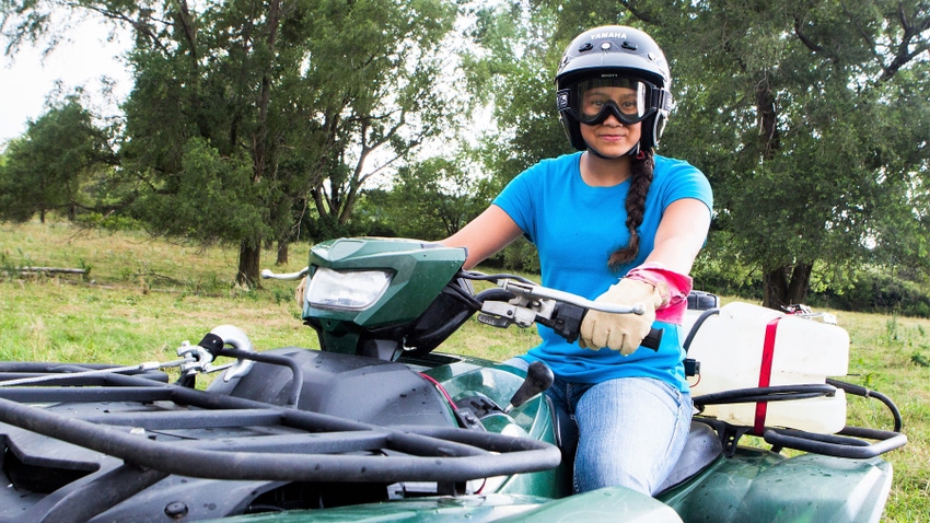 Woman on ATV wearing protective gear
