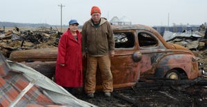 Theresa and Jim Farley of Fowler stand in front of what is left of their 285-foot barn that burnt to the ground, Nov. 8