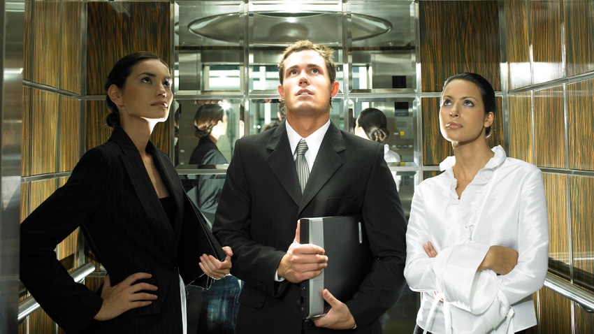 Business colleagues stand in an elevator