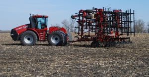 Farm equipment rests in a spring field ready for use