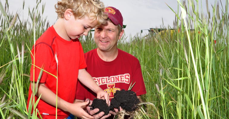 : Doug Adams with son Tyler examines the changes in the structure of the soil. 