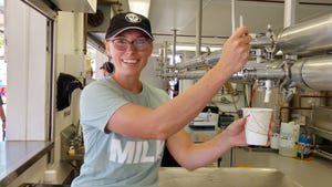 Young wojman smiles as she pours milk into a cup