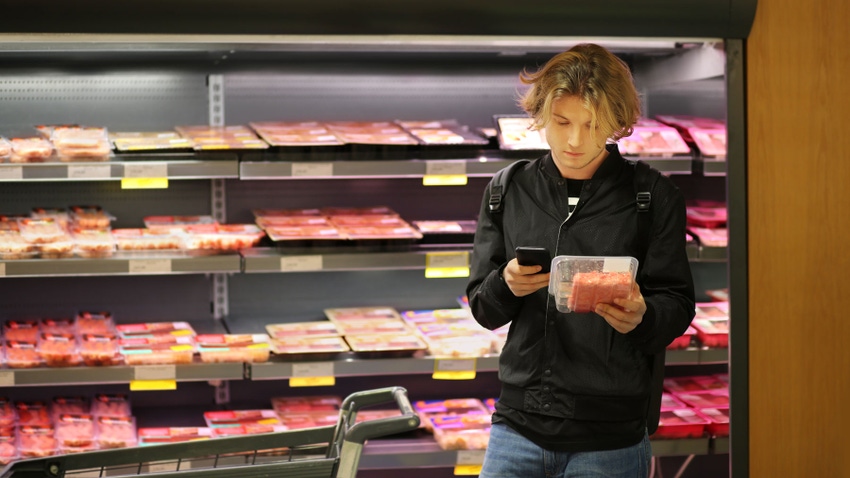 Man purchasing a packet of meat at the supermarket