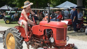 A woman driving a Massey-Harris Pony tractor
