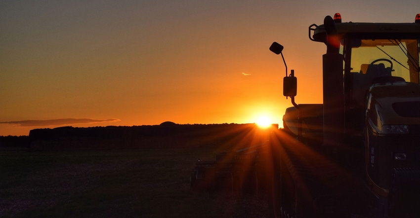 Silhouetted tractor against sunset