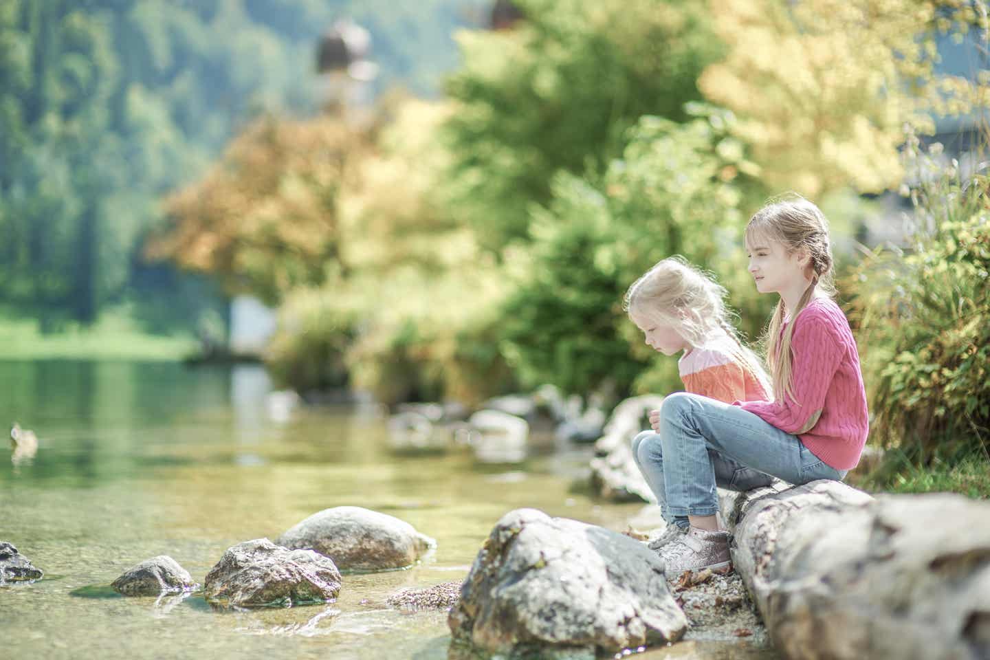 Berchtesgaden Urlaub mit DERTOUR. Zwei Mädchen spielen am Ufer des Königssees bei Berchtesgaden