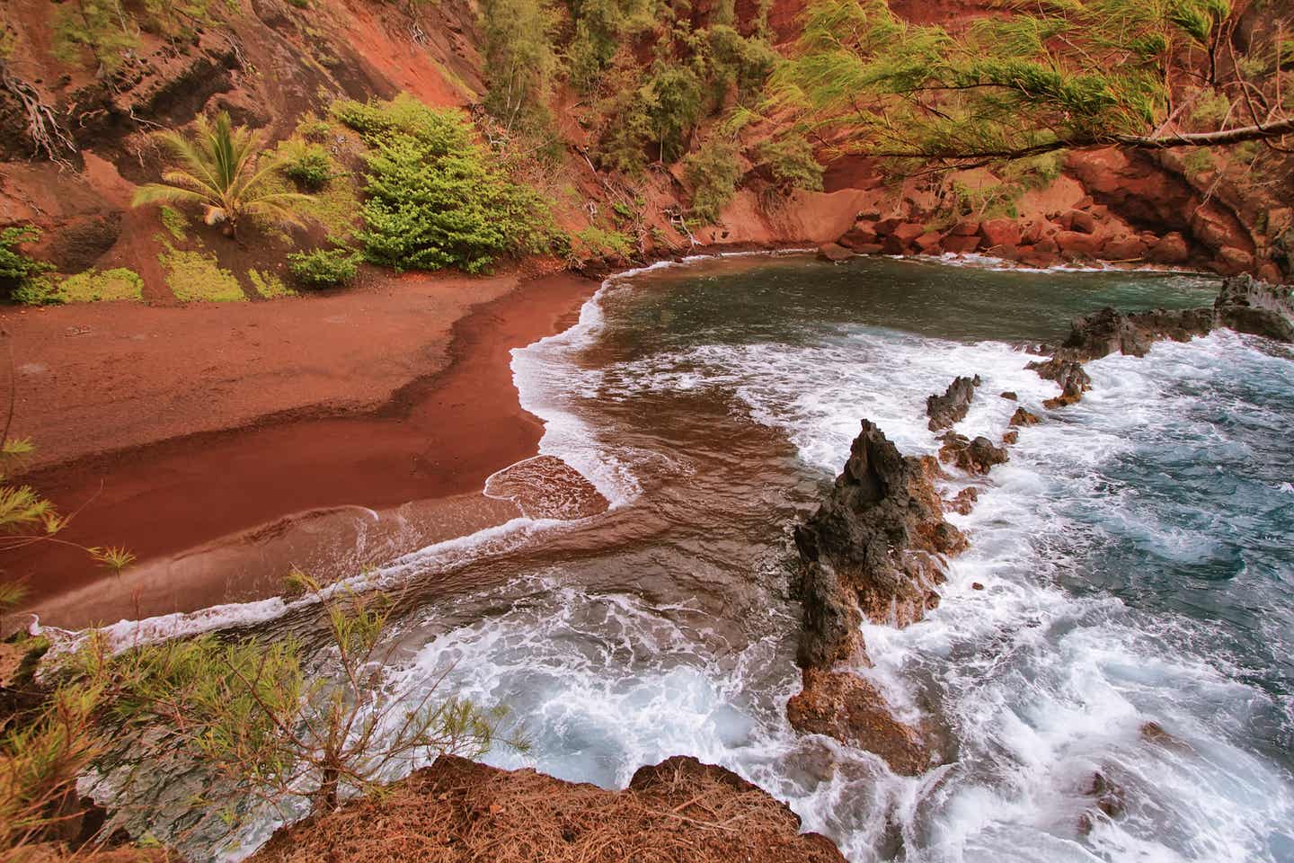 Kaihalulu Beach mit rotem Sandstrand auf der Insel Maui, Hawaii mit dramatischer Felsküste, grüner Vegetation und klarem Wasser