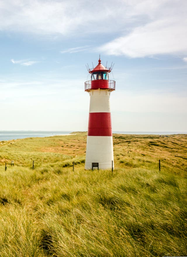 Zu den Angeboten Nordsee - Bahn & Hotel buchen - Blick auf die Dünen und den Leuchtturm auf Sylt