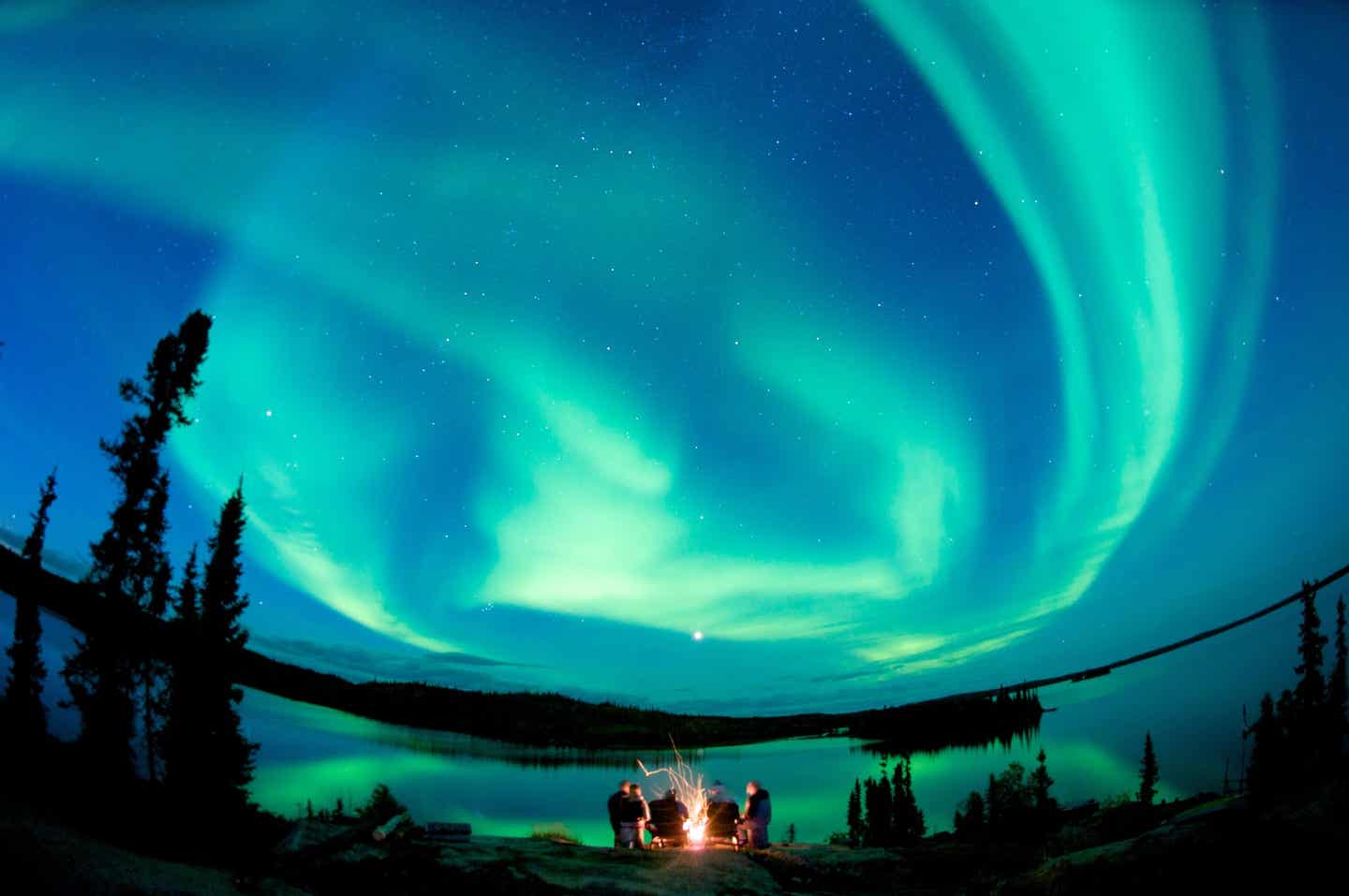 Polarlichter über Lagerfeuer im Yukon