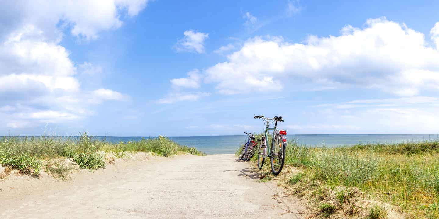 Ein Fahrrad steht auf einer Düne an der Ostsee, im Hintergrund das Meer