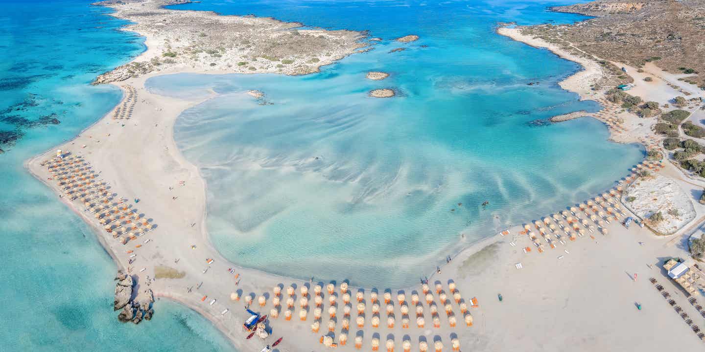 Luftaufnahme des Elafonissi Beach auf Kreta mit klarem Wasser und feinem Sand – ideal für einen Inselurlaub mit der Familie