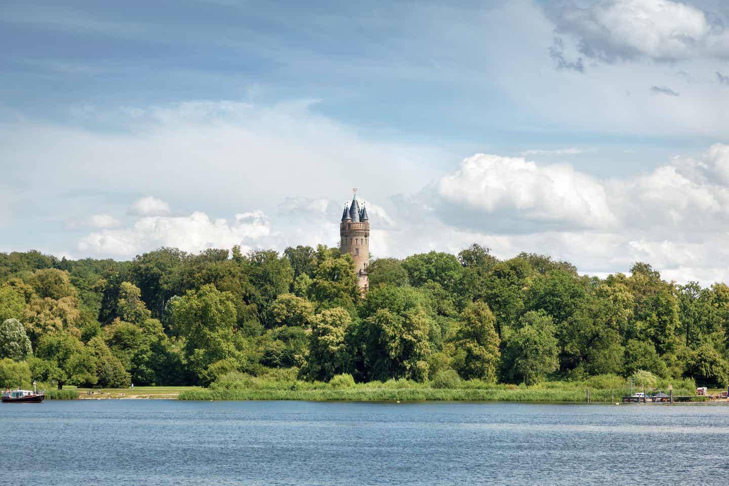 Brandenburg Urlaub mit DERTOUR. Blick übers Wasser auf den Flatowturm im Wald bei Babelsberg