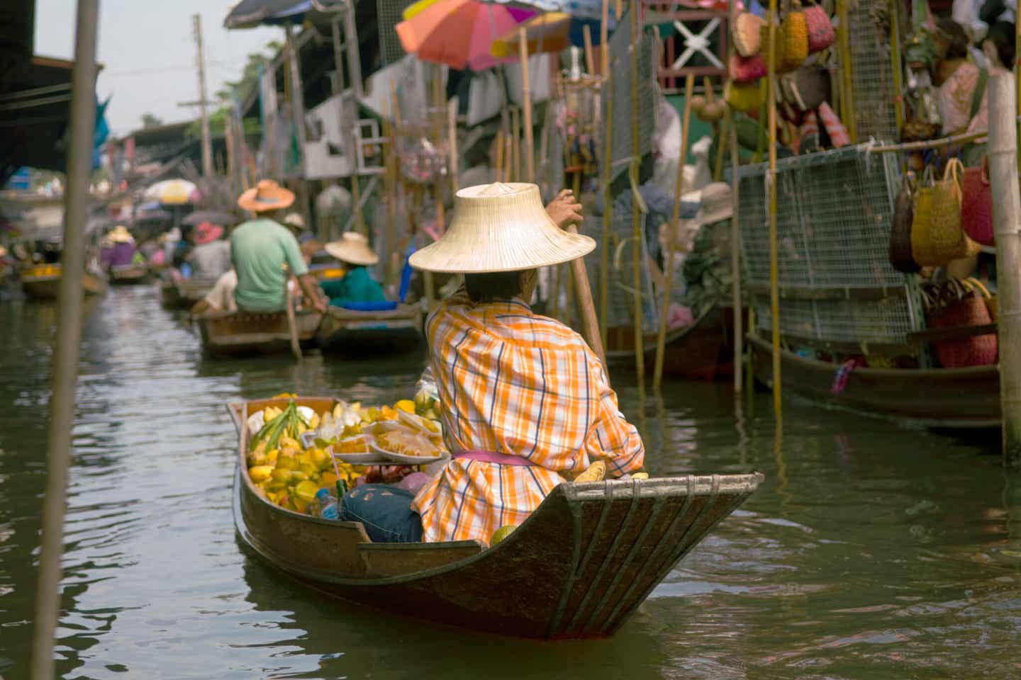 Thailänder rudern ihr Boot zum Markt