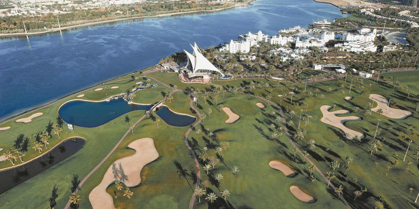 Golfball und Golfschläger auf den Greens vor der Skyline Dubais