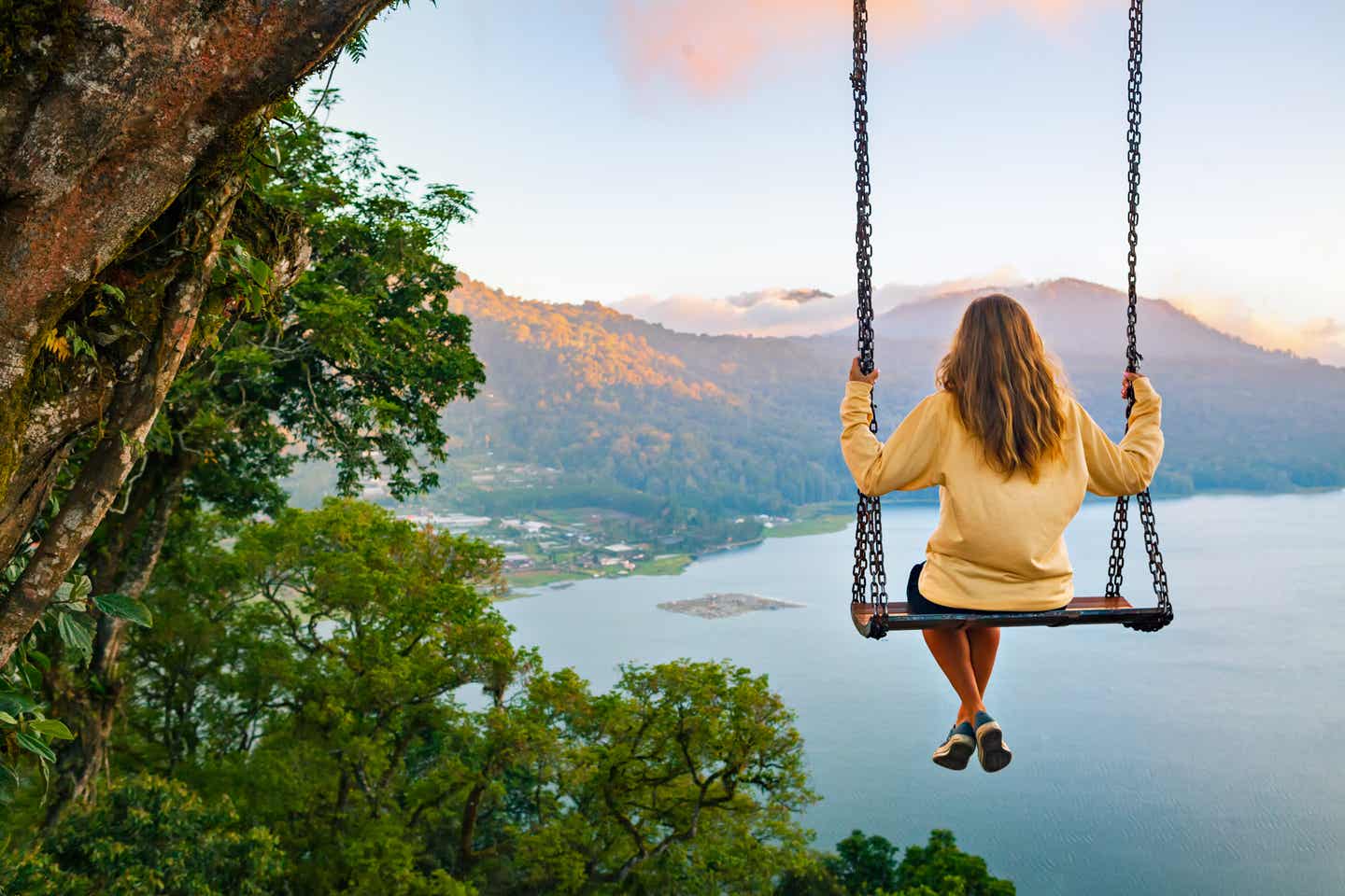 Beste Reisezeit Bali: Frau schaukelt mit Aussicht am Buyan Lake