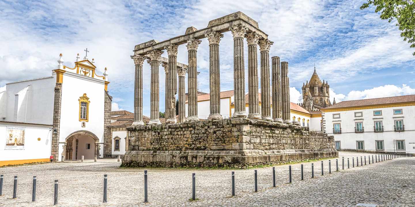 Römischer Tempel von Évora im Alentejo mit antiken Säulen und historischen Gebäuden unter blauem Himmel