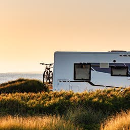 usa-camper-mit-fahrradanhaenger-zwischen-den-duenen-am-Strand-g-1256442677.jpg