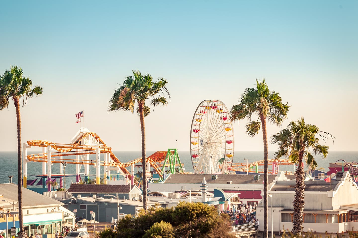 Achterbahn und Riesenrad mit Palmen im Vordergrund in Santa Monica