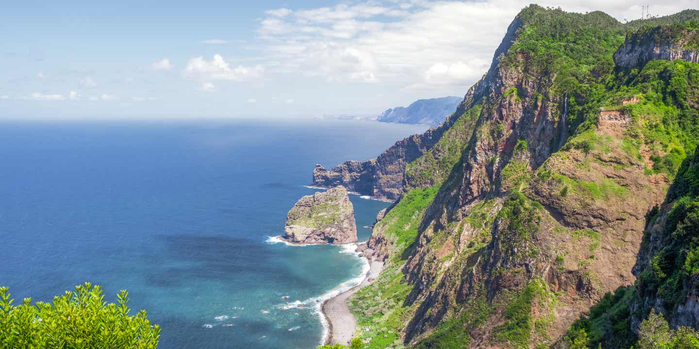 Luftaufnahme von Madeiras Steilküste mit grün bewachsenen Klippen und dunkelblauem Wasser