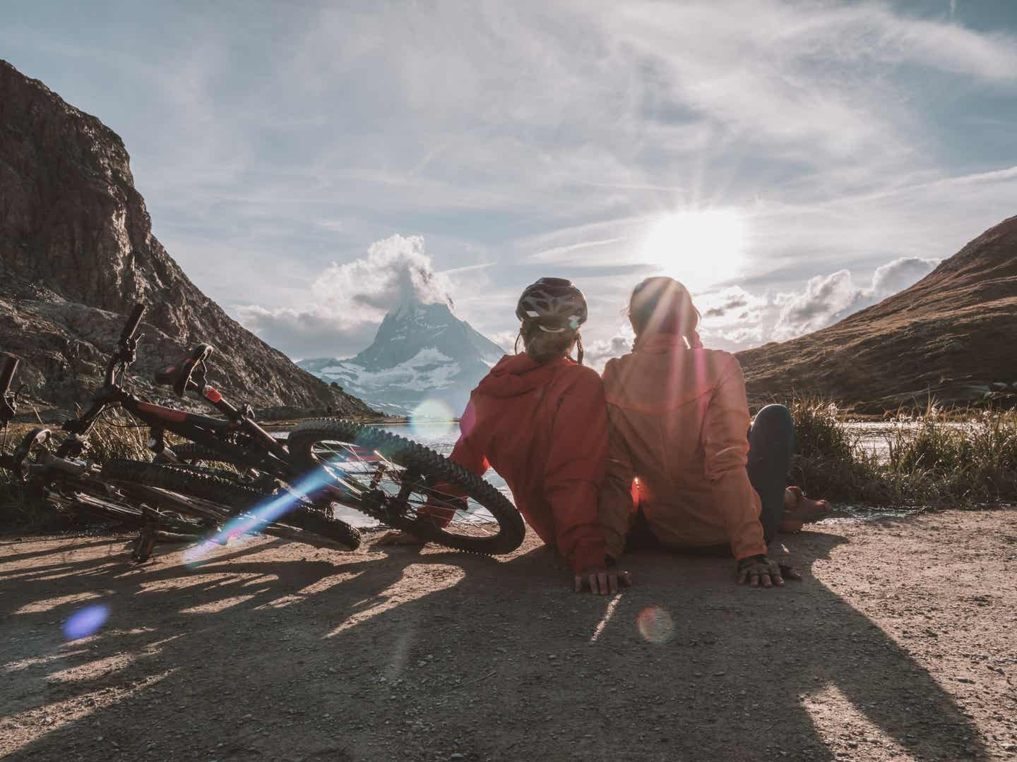 Schweiz Urlaub mit DERTOUR. Paar macht eine Pause vom Mountainbiking in den Schweizer Alpen