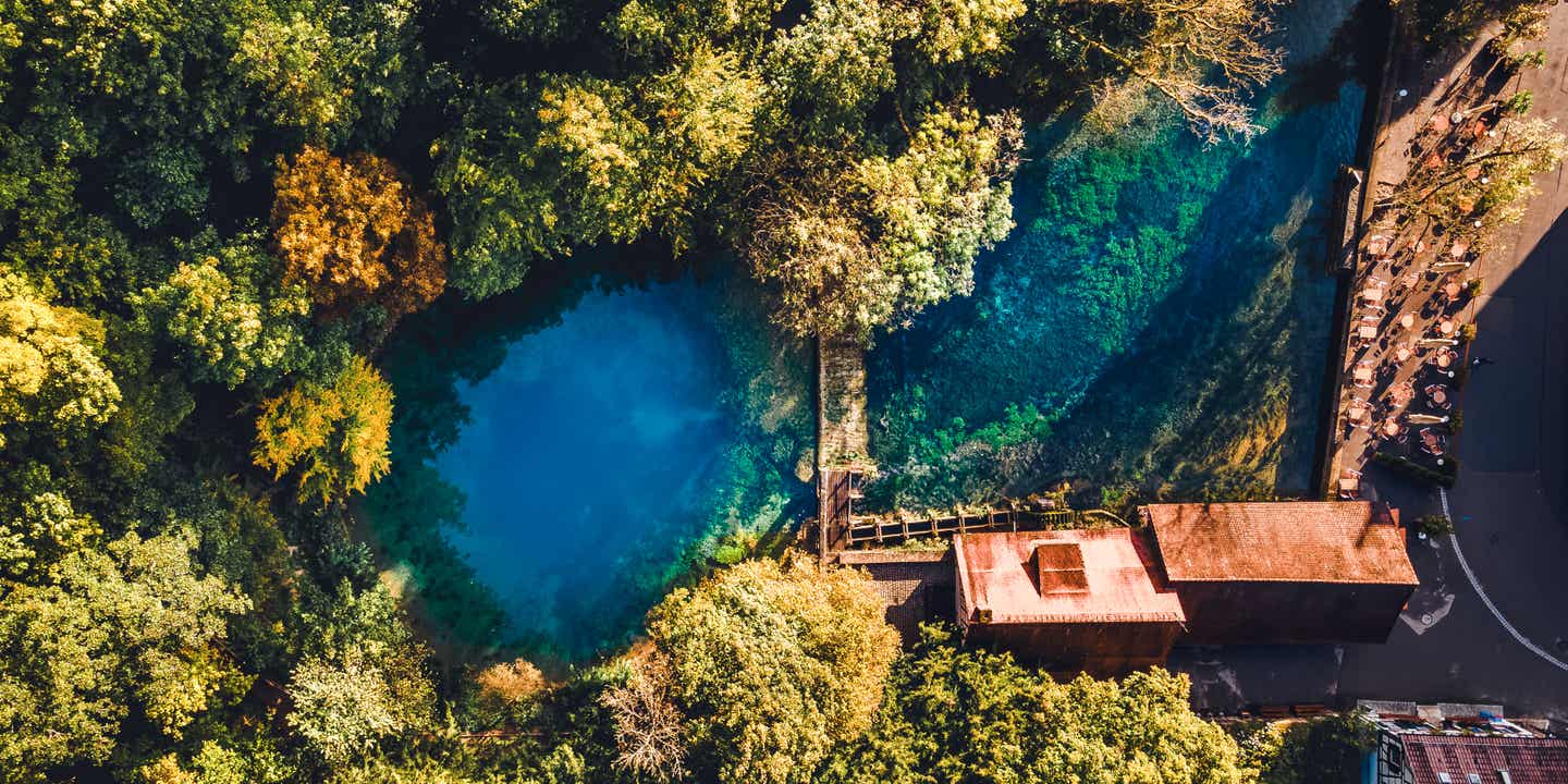 Luftaufnahme des Blautopfs in Blaubeuren mit tiefblauem Wasser und umliegender Natur