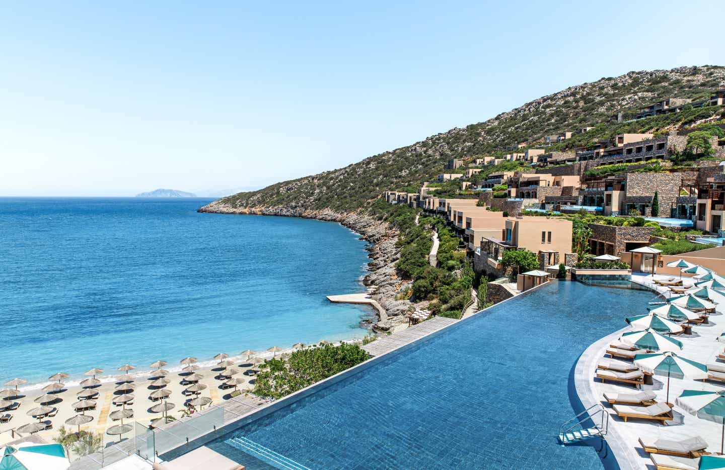 Pool und Strand mit Sonnenschirmen im Hintergrund