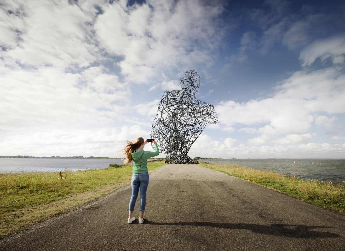 Frau vor großer Skulptur auf der Floriade in der Provinz Flevoland
