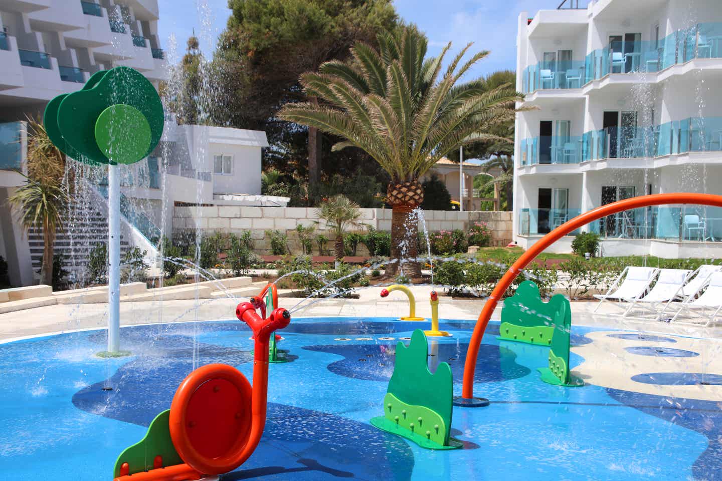 Beste Familienhotels Mallorca – Kinder-Wasserspielplatz im Iberostar Selection Playa de Muro Village mit bunten Spielen und sprudelnden Wasserfontänen