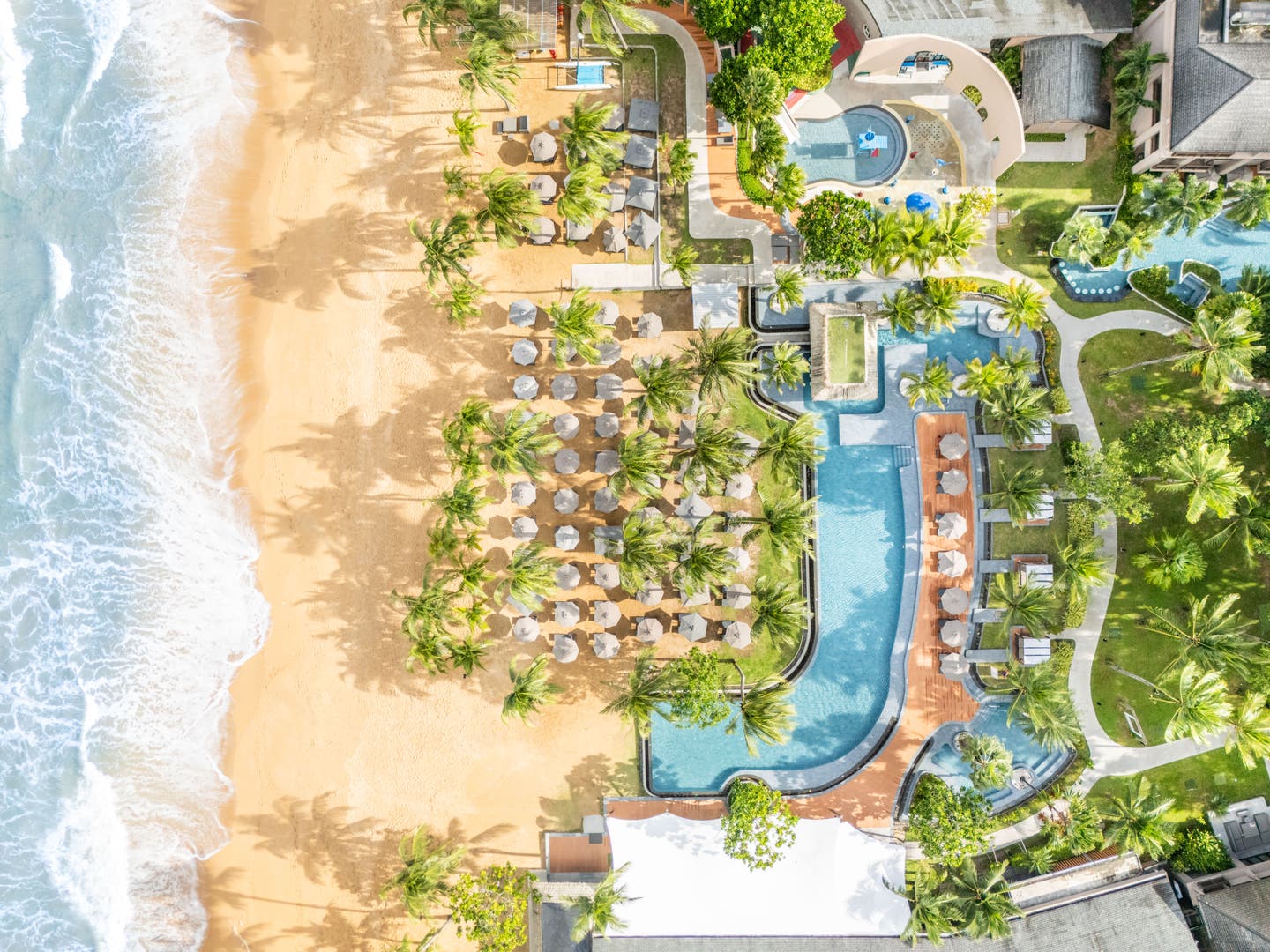 Topshot einer Drohne auf die gesamte Hotelanlage mit Strand