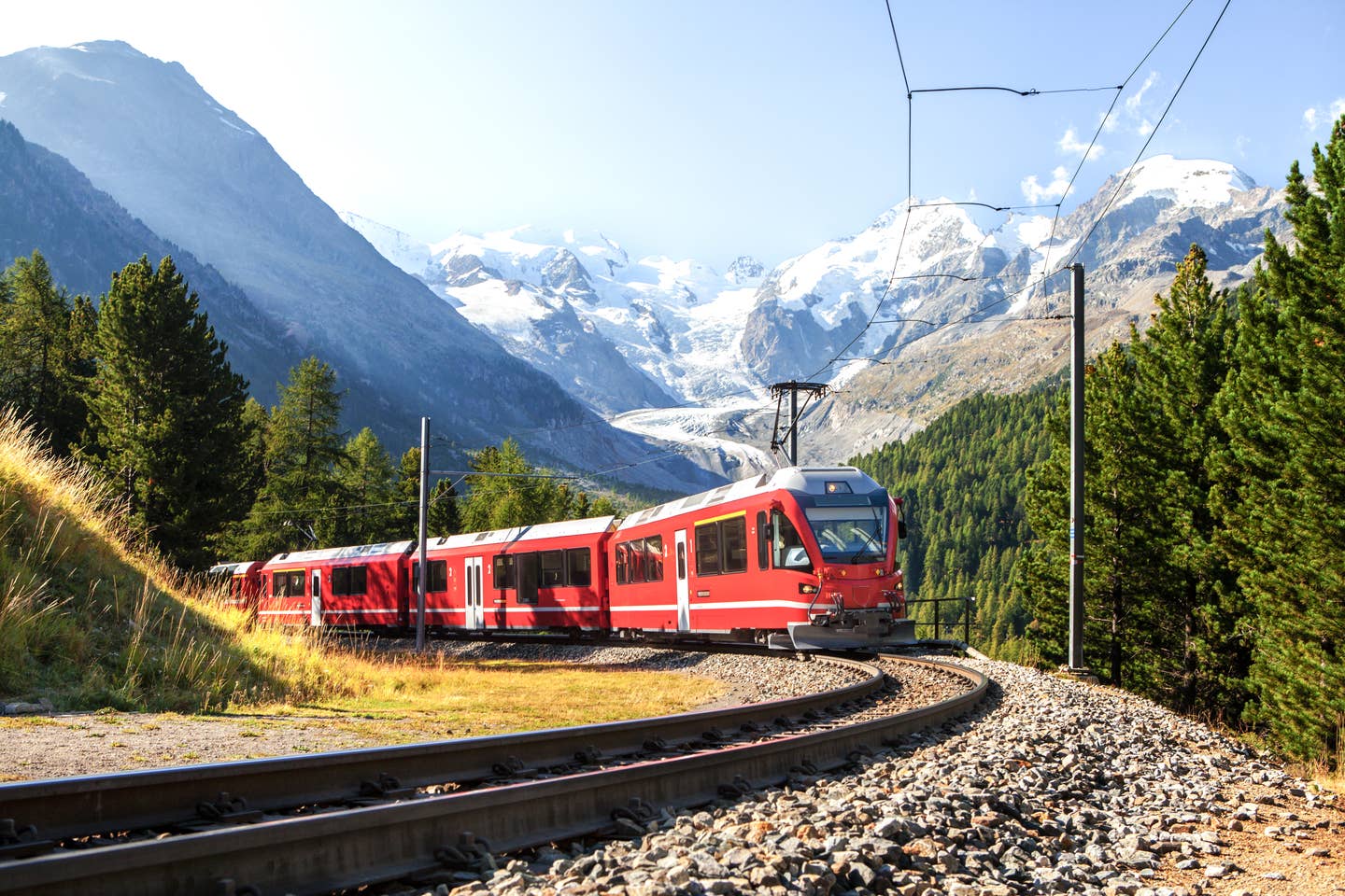 Städtereise mit der Bahn: Zug in Berglandschaft von den Alpen Städtereise mit der Bahn: Zug in Berglandschaft von den Alpen