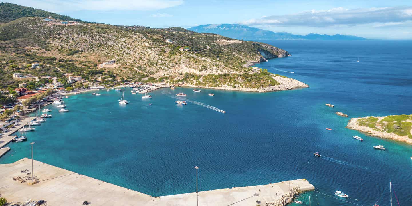 Agios-Nikolaos-Bucht auf Zakynthos mit Segelbooten, Hafenmole und Blick auf das türkisfarbene Meer