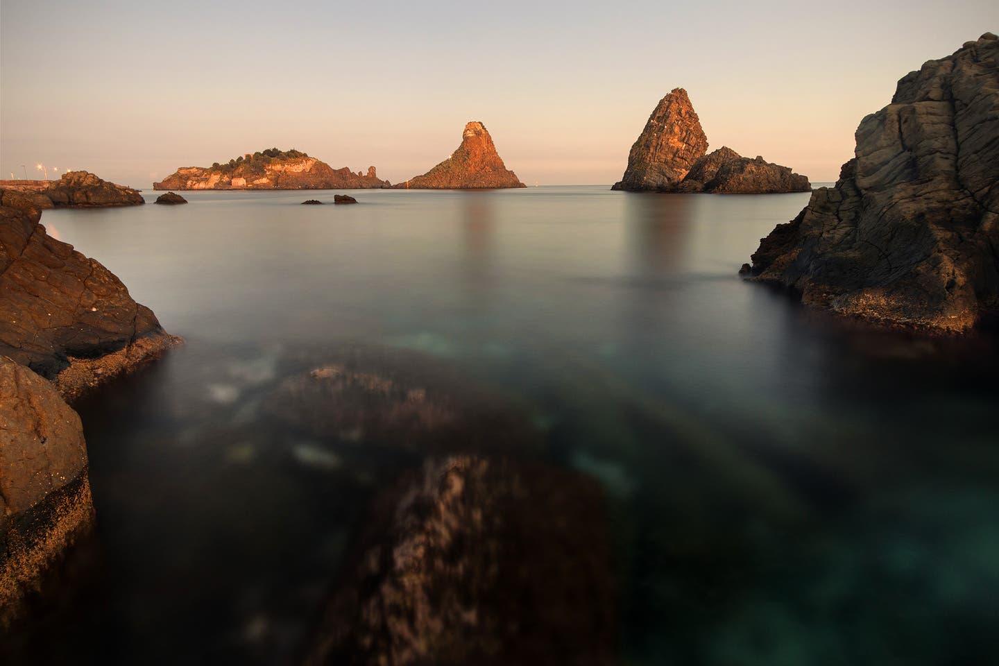 Sonnenuntergang an der Zyklopenküste mit Blick auf Lavafelsen