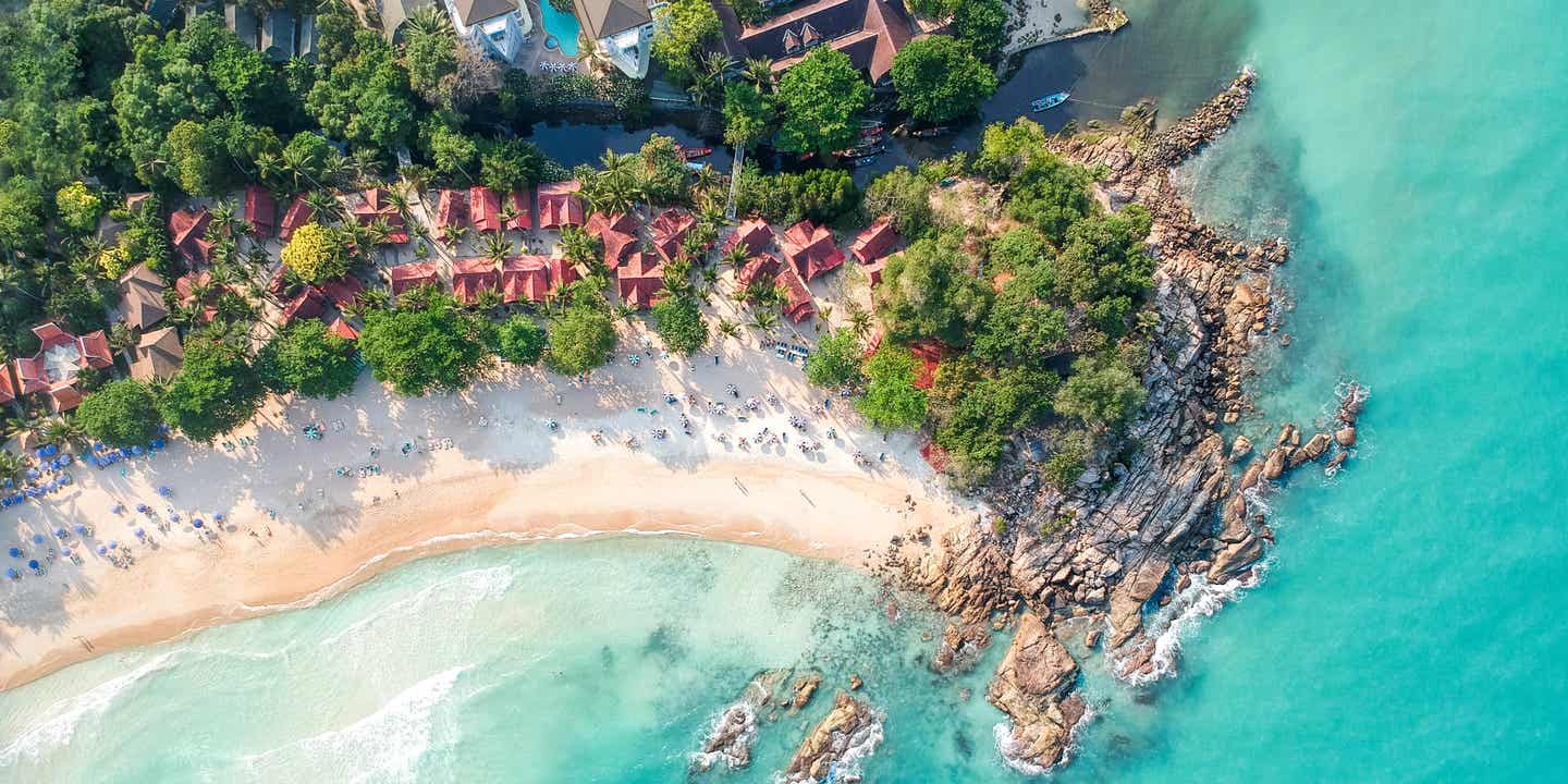 Drohnenaufnahme vom Chaweng Beach, einem der bekannten Koh Samui Strände mit Hotelanlagen, Felsen und türkisfarbenem Meer