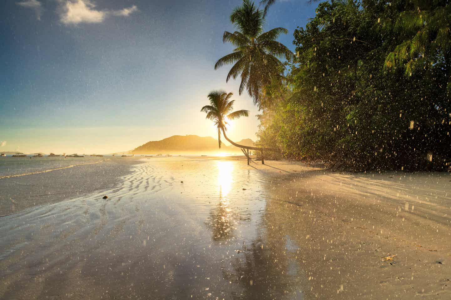 Tropischer Regen bei Sonnenuntergang am Strand