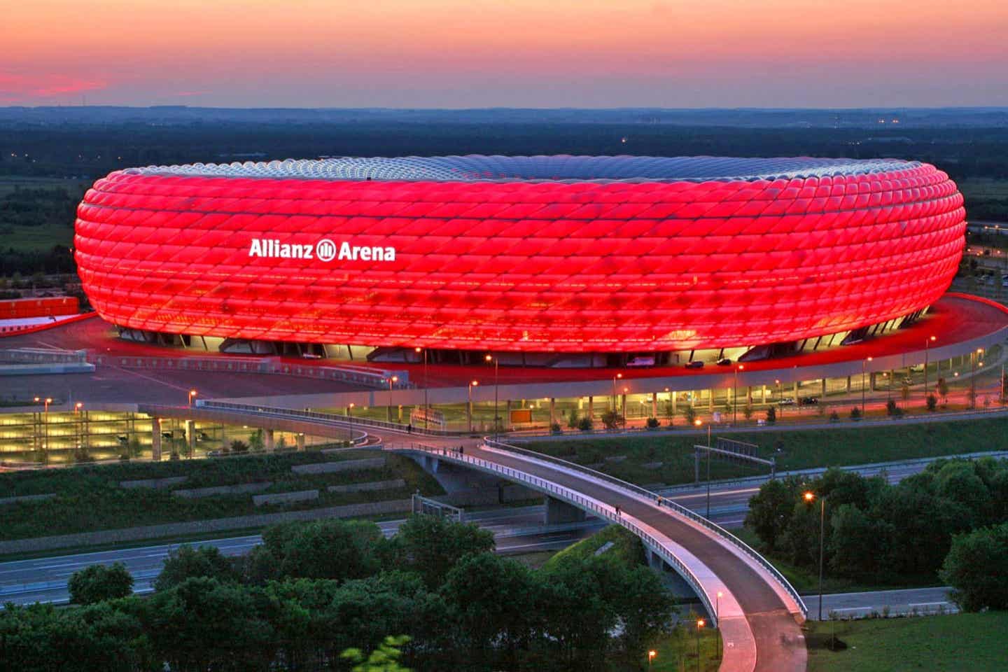 Bayern München Tickets. Erleuchtete Allianz Arena in der Abenddämmerung.