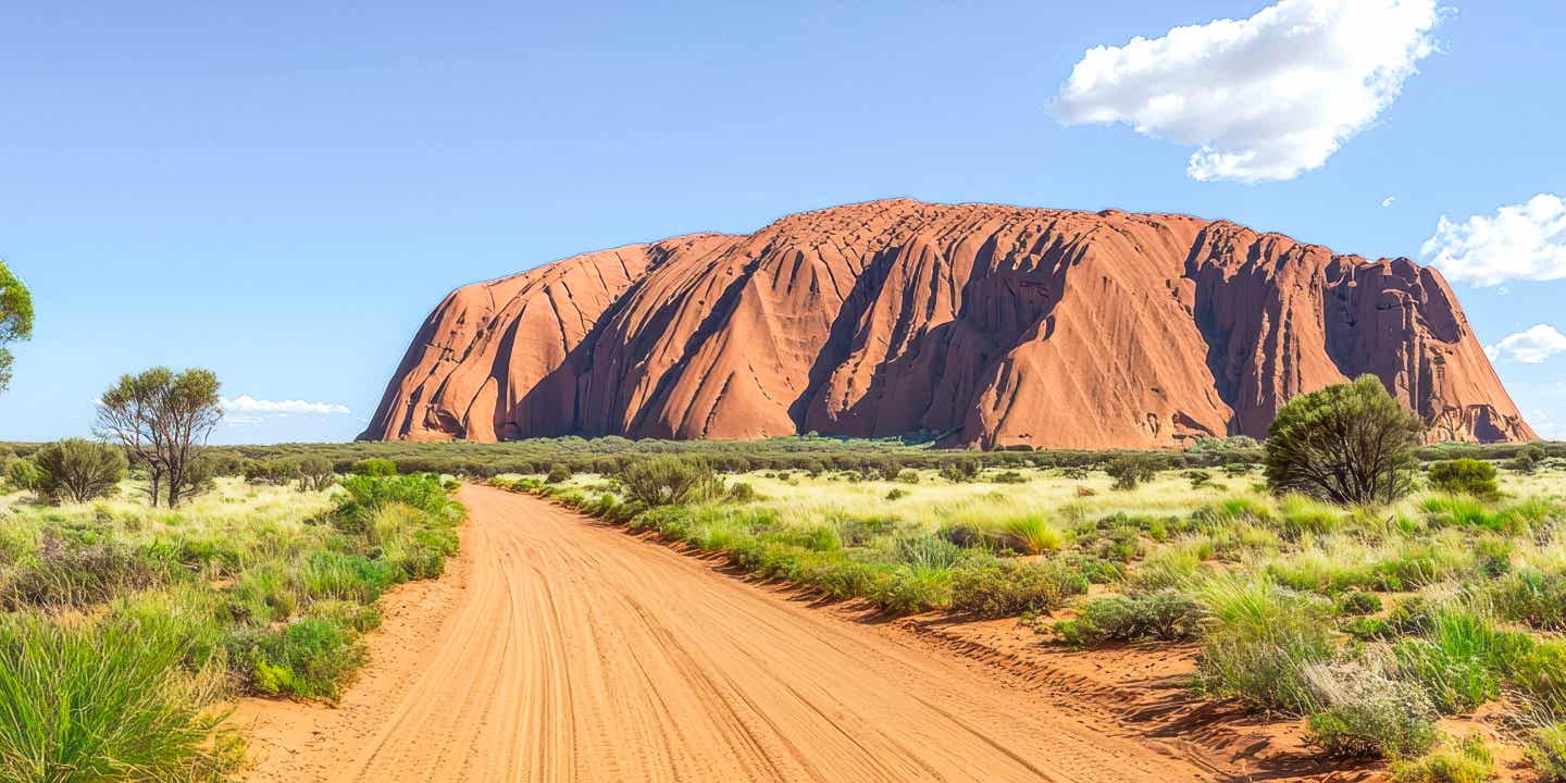 Outback-Piste mit Blick auf Uluru im roten Zentrum Australiens 
