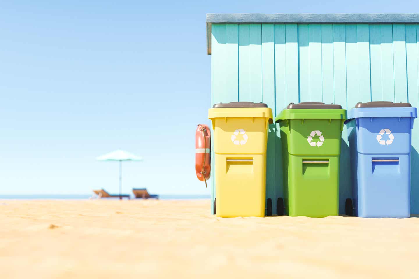 Nachhaltige Recyclingtonnen an einem türkisfarbenen Strandhäuschen; im Hintergrund zwei Liegen und ein Sonnenschirm