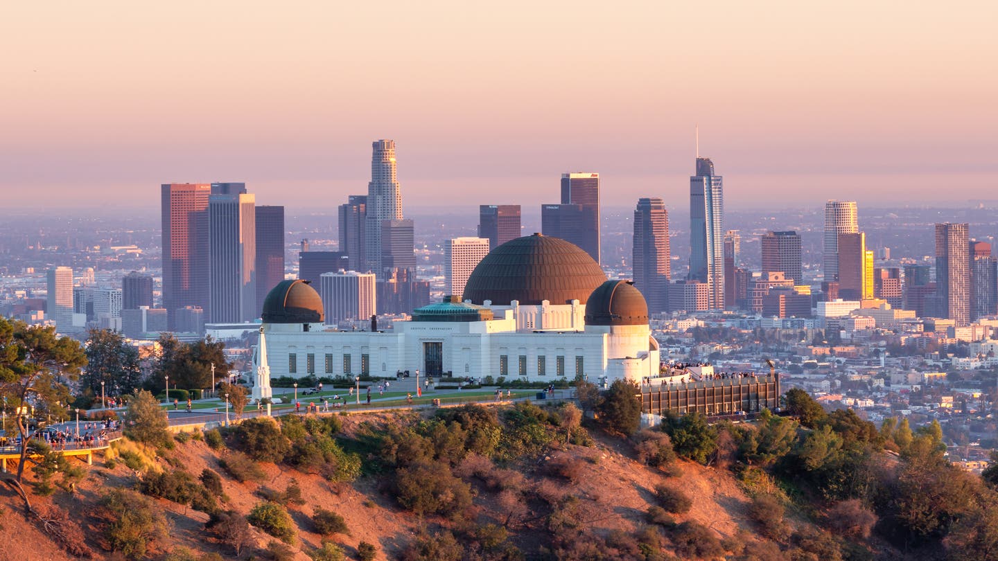 Das Griffith Observatorium bei Abenddämmerung mit Los Angeles‘ Skyline im Hintergrund