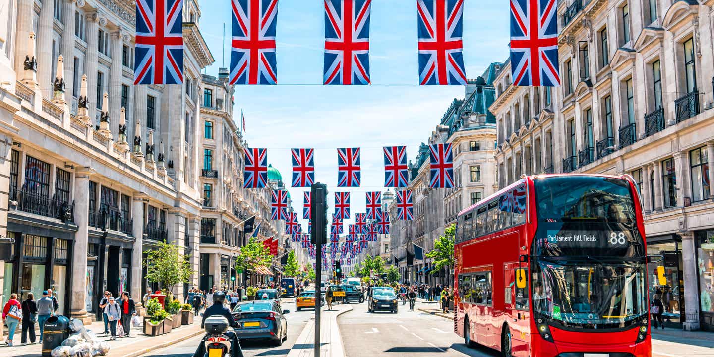 Blick in Londons Oxford Street mit Union Jack-Flaggen und einem typisch englischen roten Doppeldecker