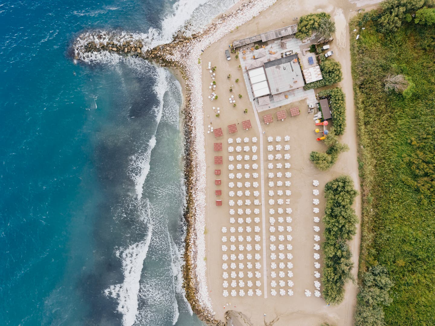 Topshot der Strandanlage mit zahlreichen Sonnenliegen